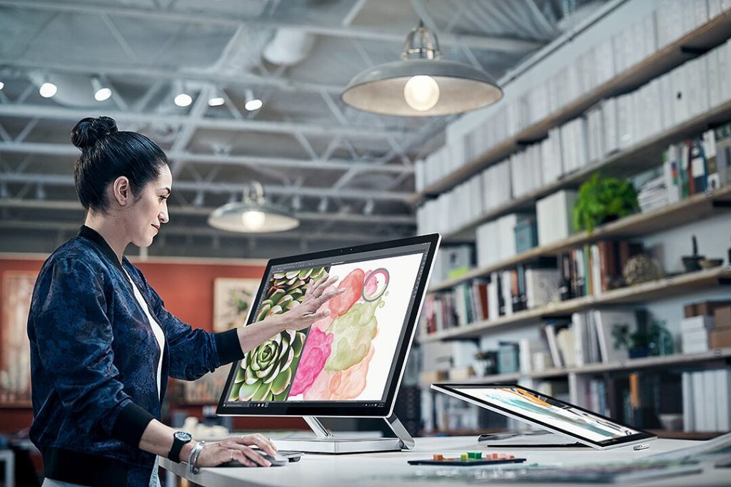 Surface in einem Büro an dem eine Frau Bilder bearbeitet