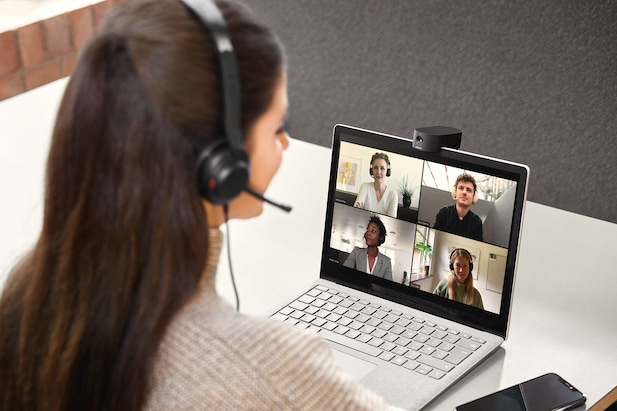 Frau mit Headset die vor einem Laptop