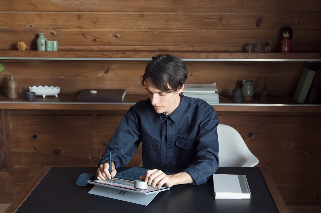 Mann sitzt in einem Büro an einem Surface