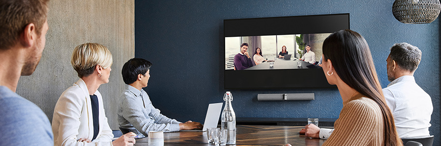 Jabra Panacast Konferenzraum mit mehreren Personen die auf ein Display schauen