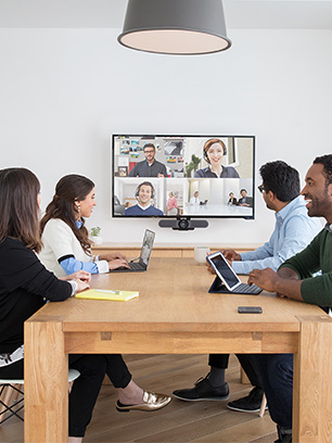 Konferenzraum mit mehreren Personen und einem Display