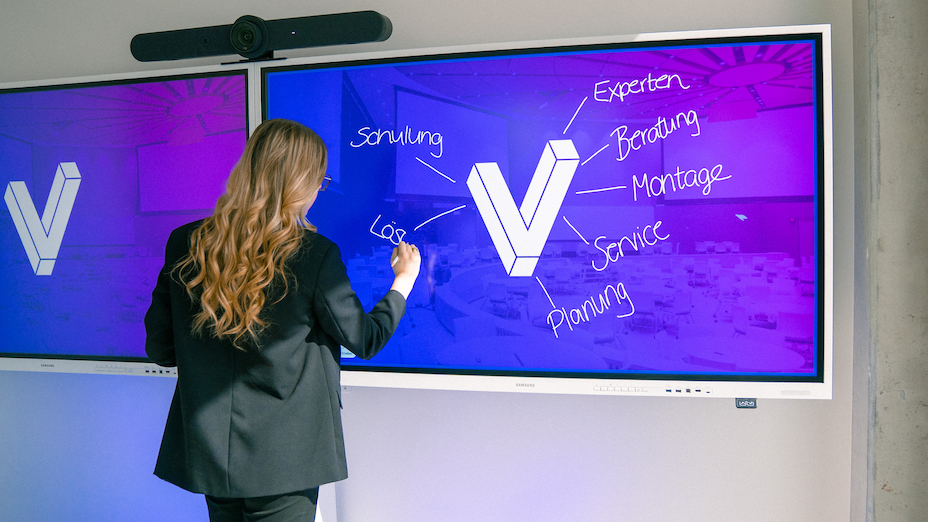 Eine Frau steht vor einem Samsung Flip und schreibt auf die Digitale Tafel Serviceleistungen von visunext auf