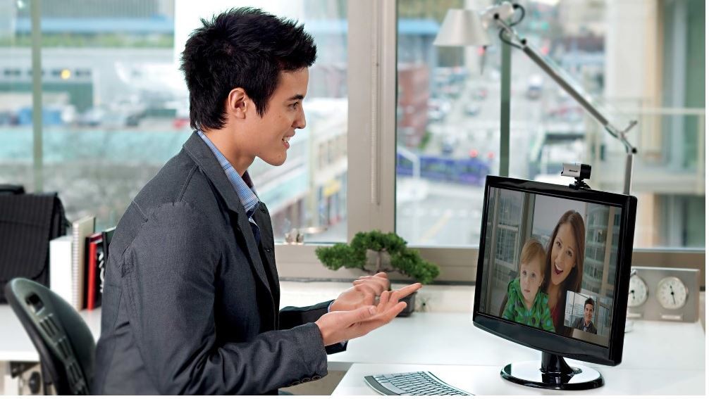 Frau sitzt in einem Büro vor einem Monitor mit Microsoft LifeCam 
