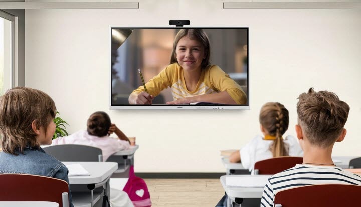 Eine Schülerin wird digital zu einer Klasse geschaltet, die im Klassenzimmer sitzen.