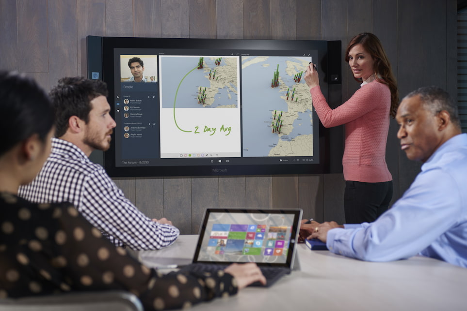 4 Personen in einem Konferenzraum arbeiten mit einem Laptop sowie einem Display