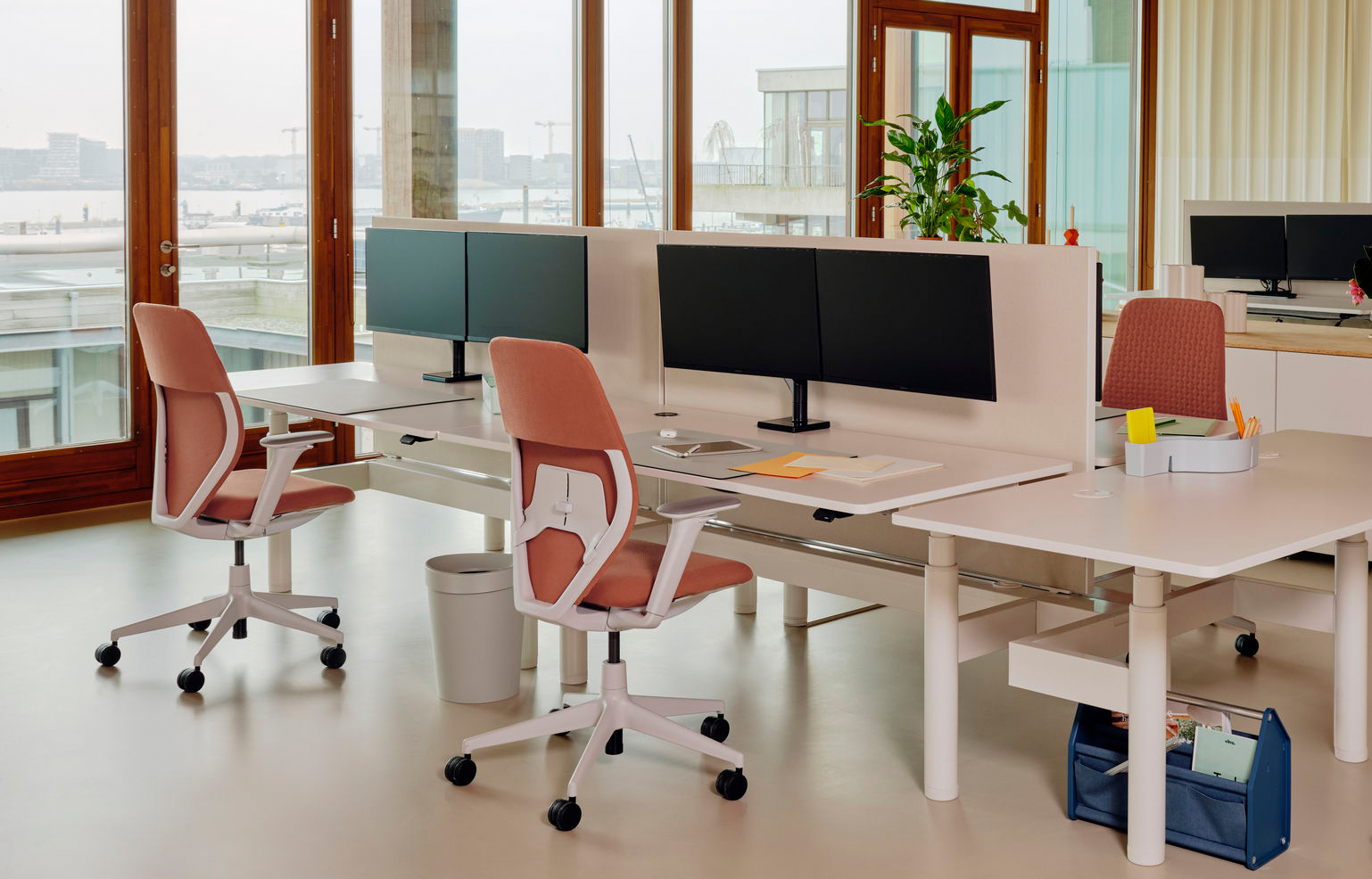 Moderner Arbeitsbereich mit Schreibtisch, Bürostuhl, Monitoren und Akustikelementen